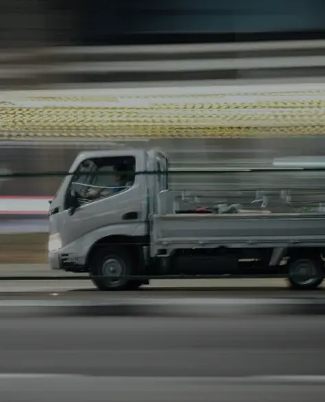 A small truck driving at high speed that even background is blured